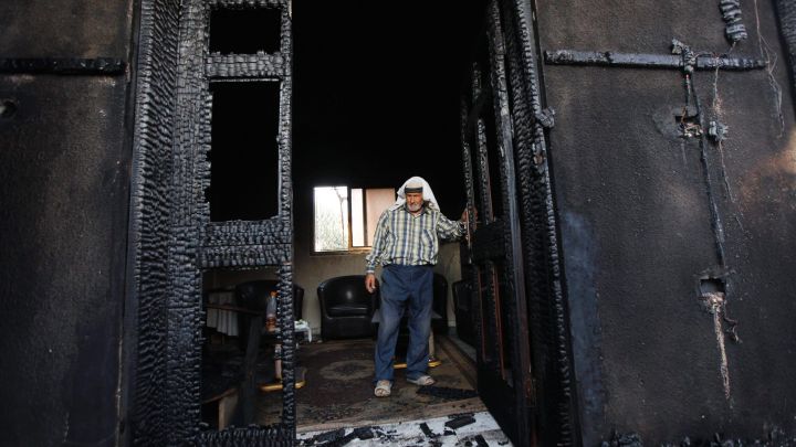 Un palestinese esamina la casa della famiglia Dawabsheh, incendiata nel villaggio di Duma, vicino alla città di Nablus in Cisgiordania. 31 luglio 2015. AP